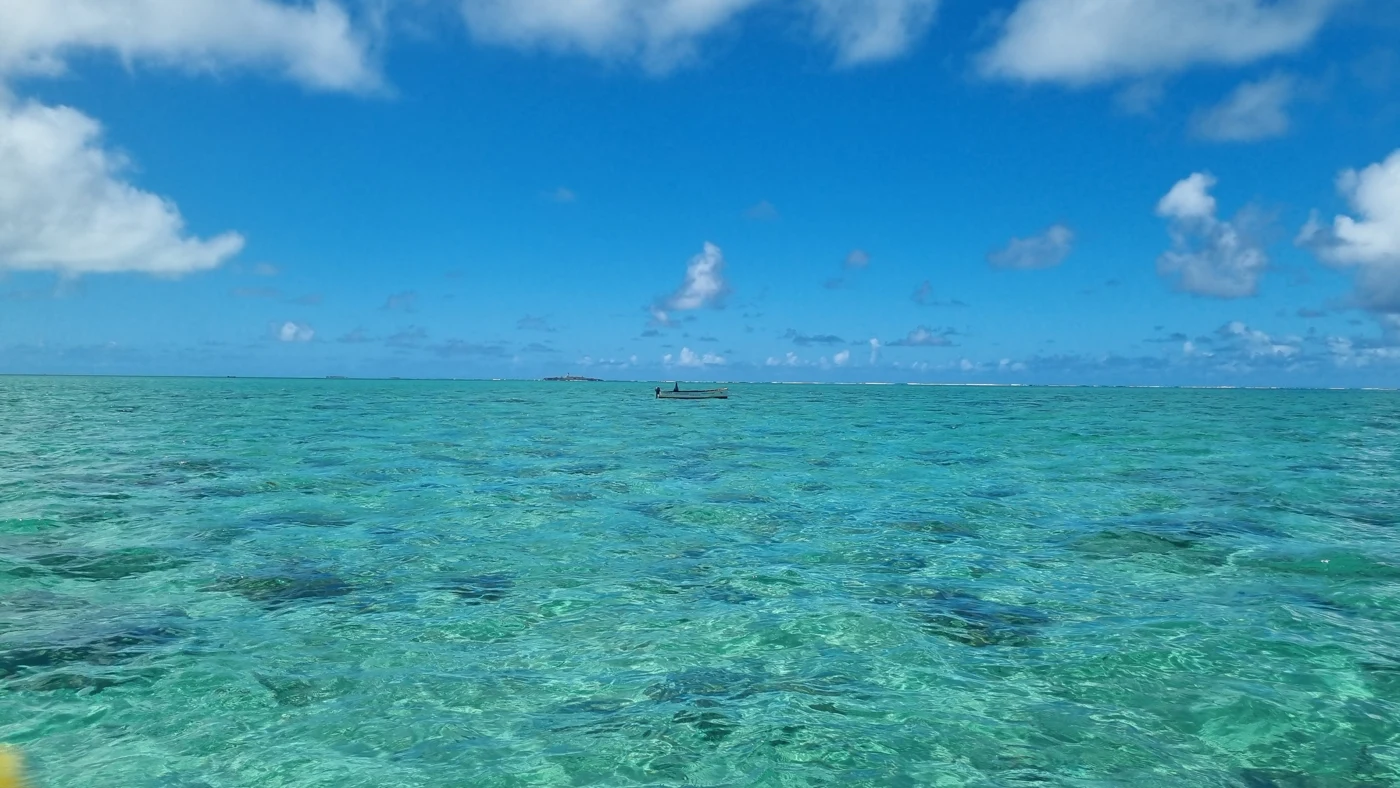 A small boat on clear turquoise sea in Fiji